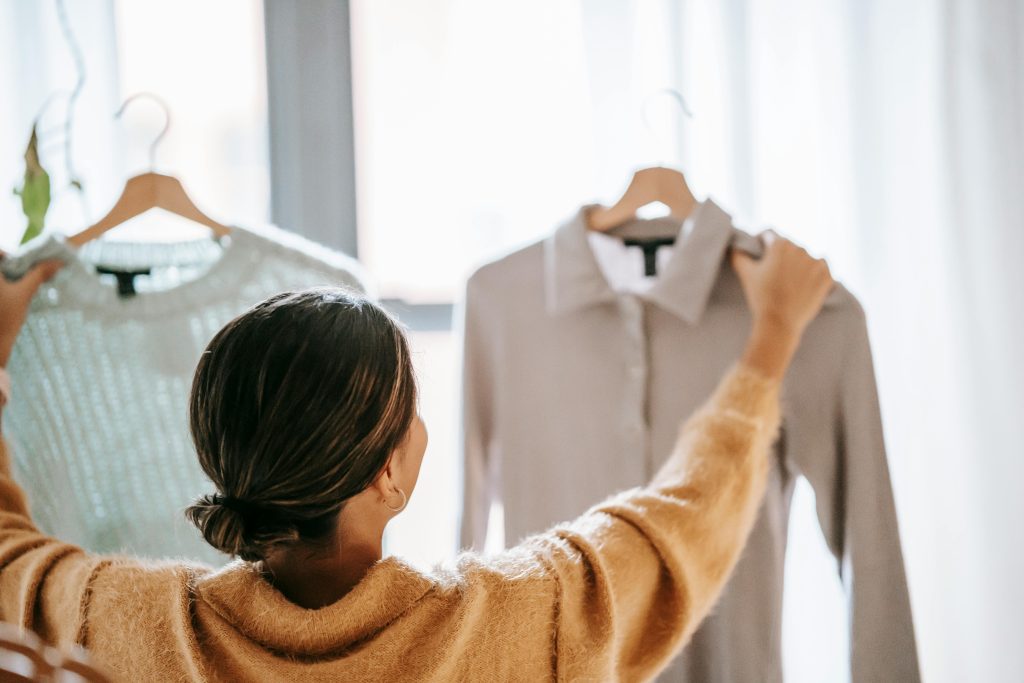 Woman holding up two different shirt options.